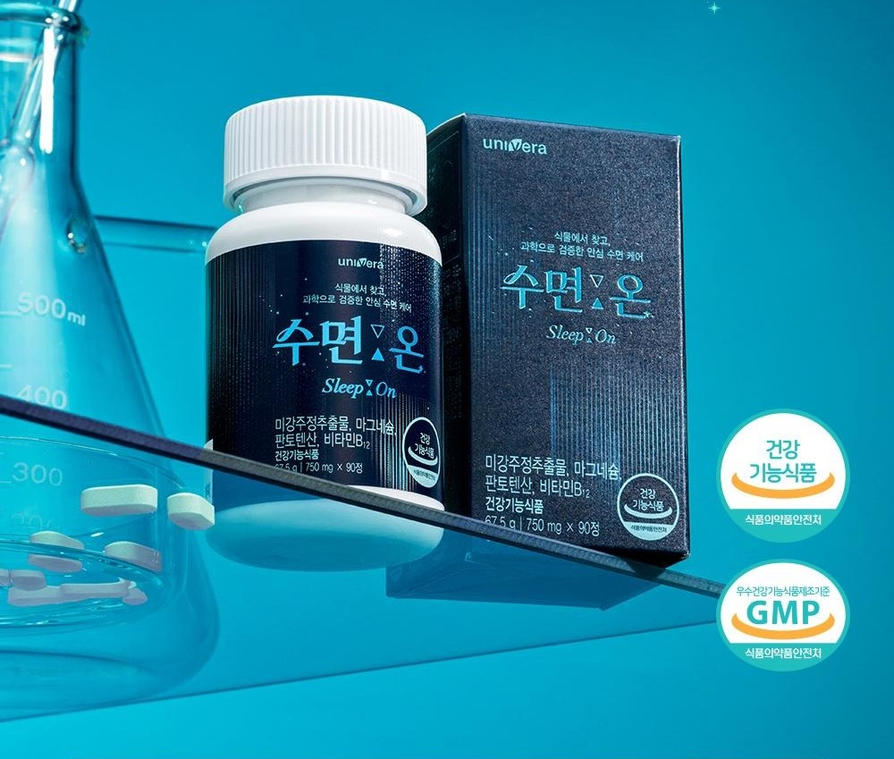 수면:온 90정 병과 종이 상자가 청록색 유리 선반 위에 놓인 연출 컷. 오른쪽에 식품의약품안전처 건강기능식품 마크와 우수건강기능식품제조기준 GMP 마크가 있다